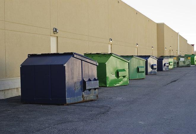 construction workers carrying construction debris to a dumpster in Fairburn, GA